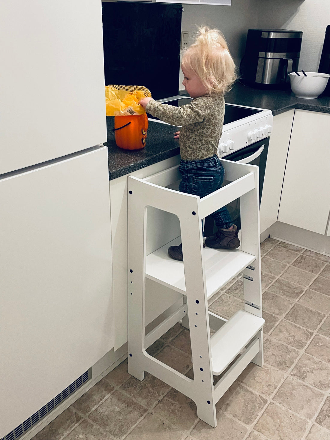 Barn i kökstorn vid köksbänken