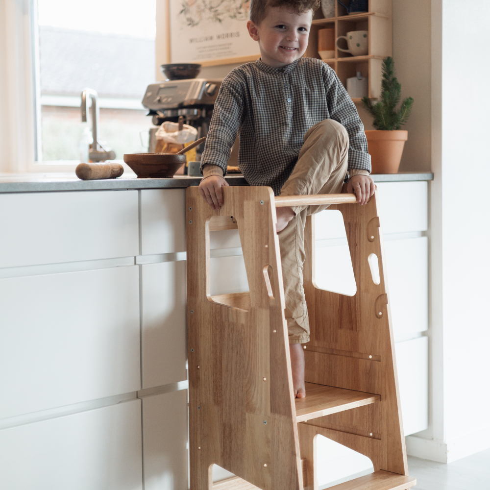 Glatt barn i lärtorn i köket