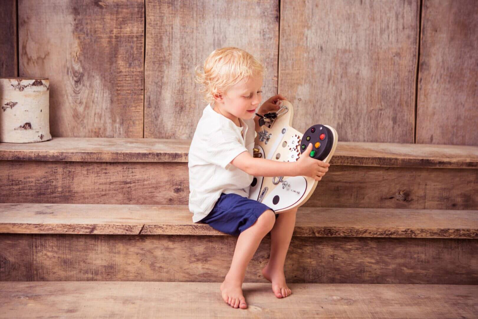 dreng sidder på trappe med sin aktivitetstavle
